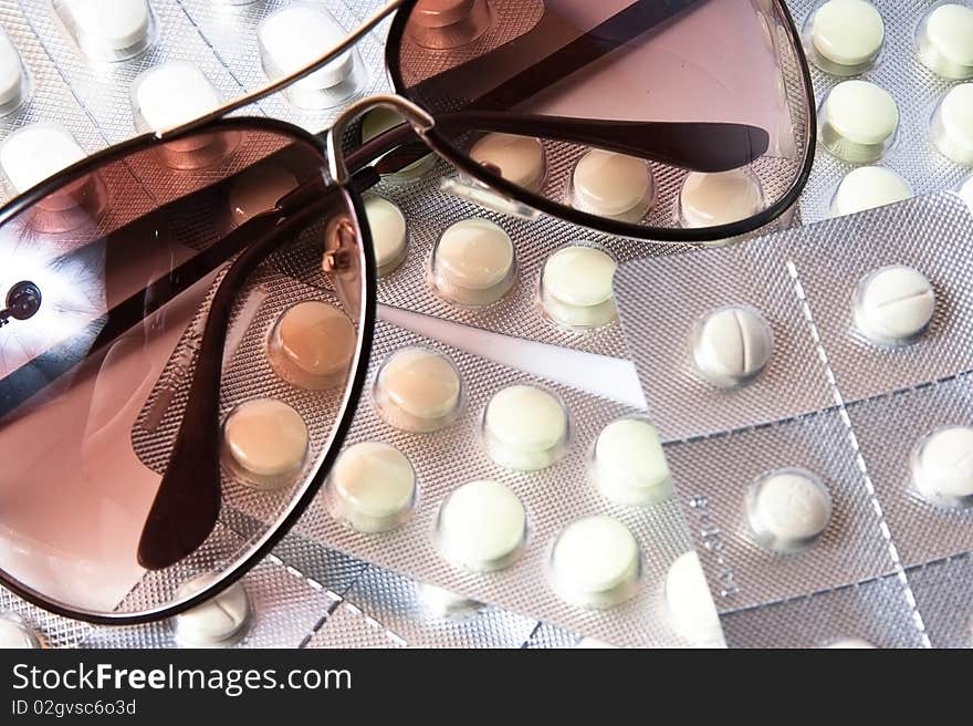 Sunglasses and tablets on white background. Sunglasses and tablets on white background