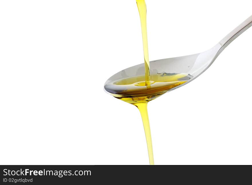 Olive oil being poured into a spoon isolated on white