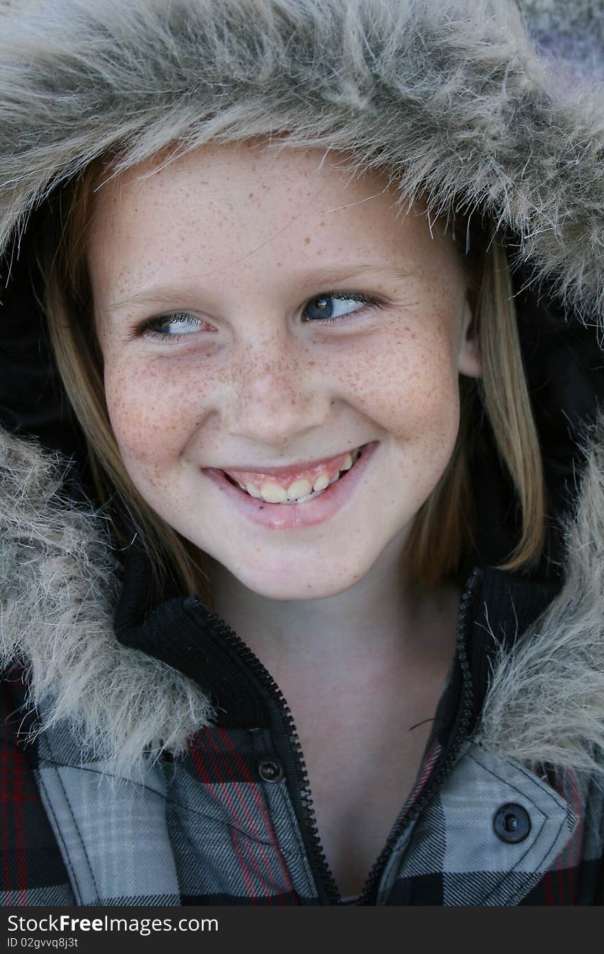 A cute white, caucasian girl child wearing a winter jacket with a big smile on her face. A cute white, caucasian girl child wearing a winter jacket with a big smile on her face.