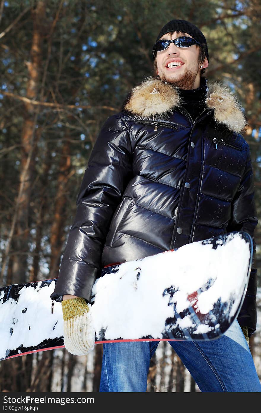 Shot of a handsome young man with a snowboard outdoor. Shot of a handsome young man with a snowboard outdoor.