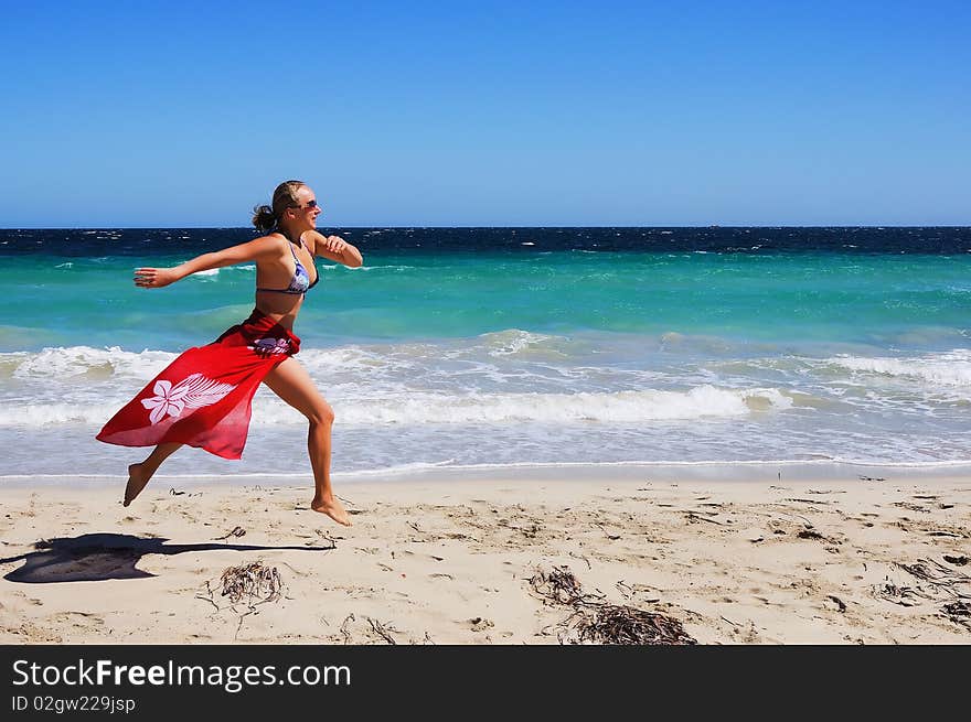 Young beautiful girl in a red shawl, ran on the beach