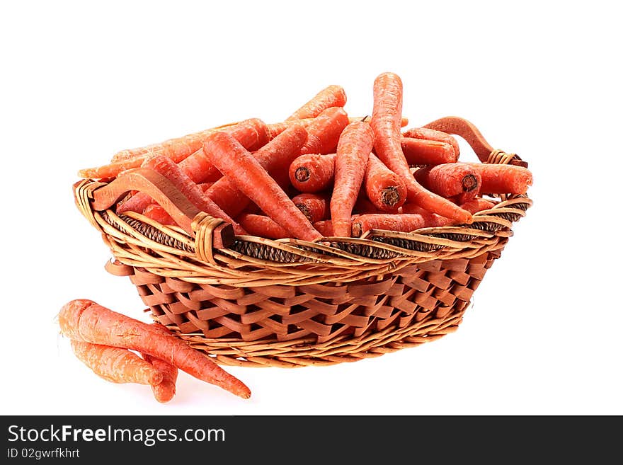 Carrot crop in a deep wattled basket on a white background.