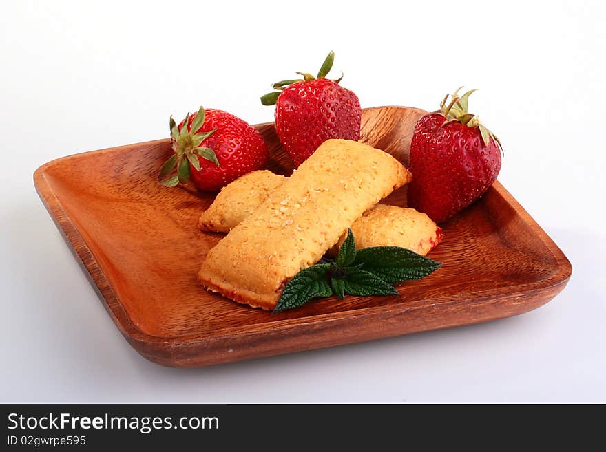 Strawberry with Cereal Bar in a wooden plate with green leaves for a decor.