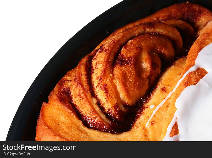 The sweet pie with cinnamon is watered from above by sugar glaze.