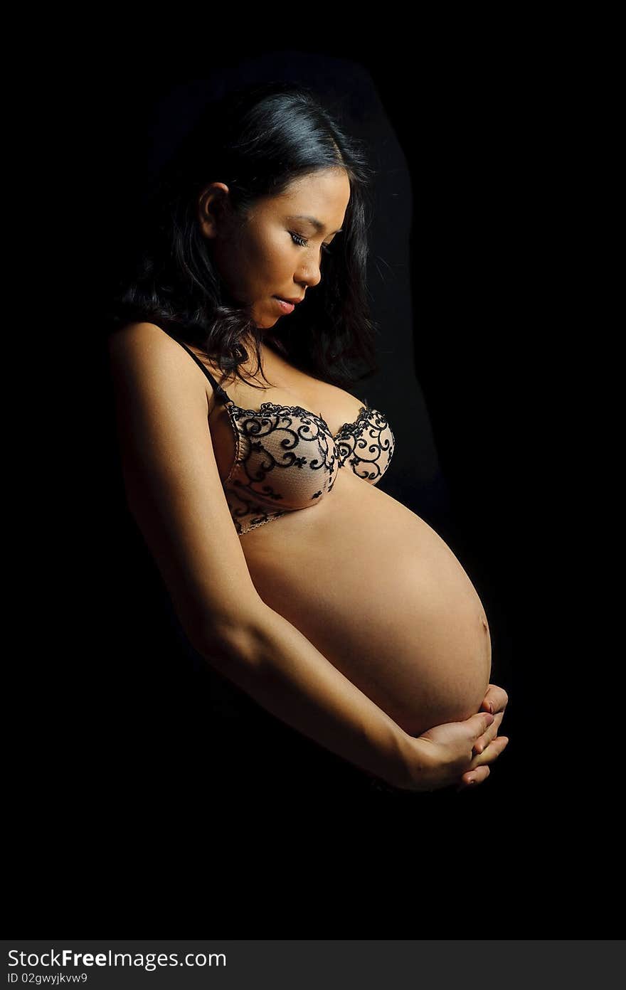 Beautiful woman is 9 months pregnant and poses in studio. Beautiful woman is 9 months pregnant and poses in studio