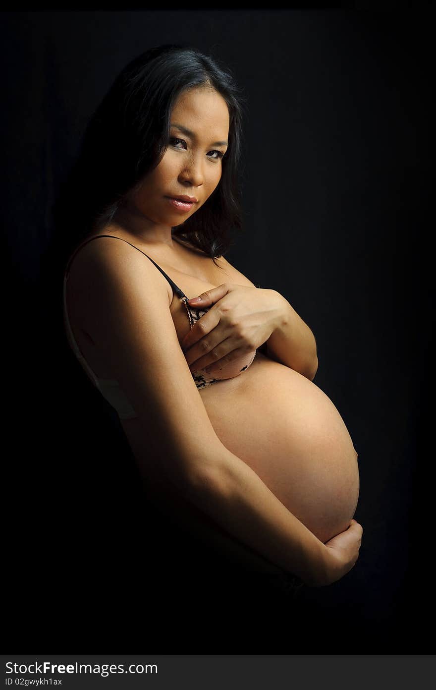 Beautiful woman is 9 months pregnant and poses in studio. Beautiful woman is 9 months pregnant and poses in studio