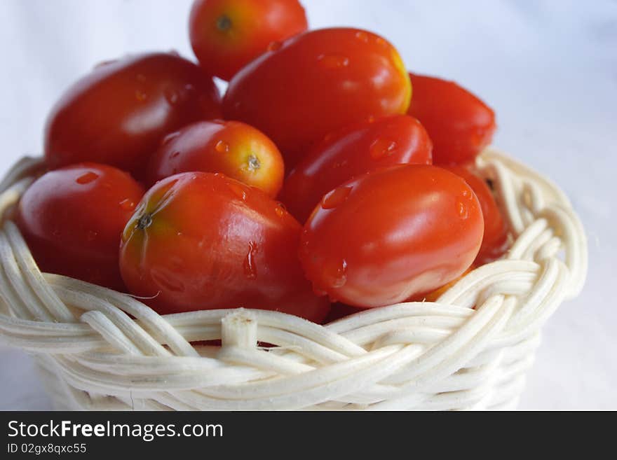 Grape tomatoes in basket with white background