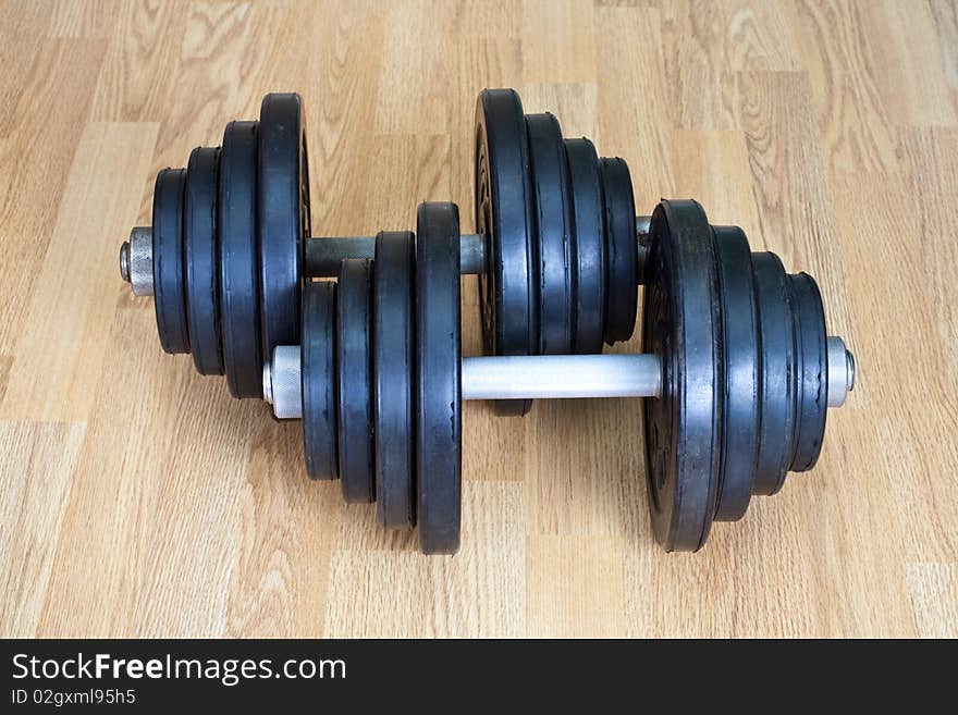 Two old dumbbells on a wood floor. Two old dumbbells on a wood floor