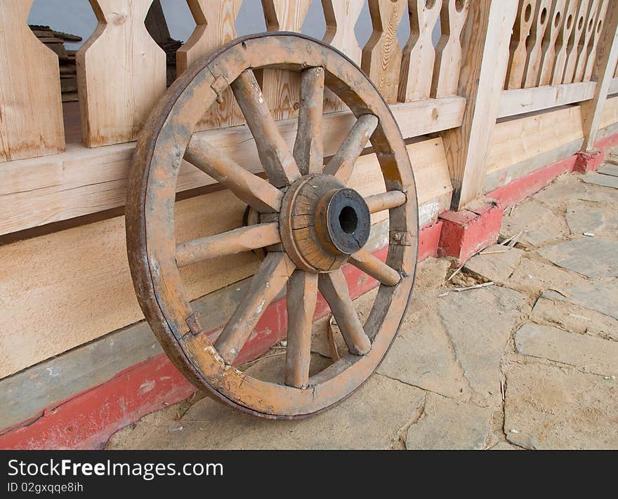 Old wooden wheel near house