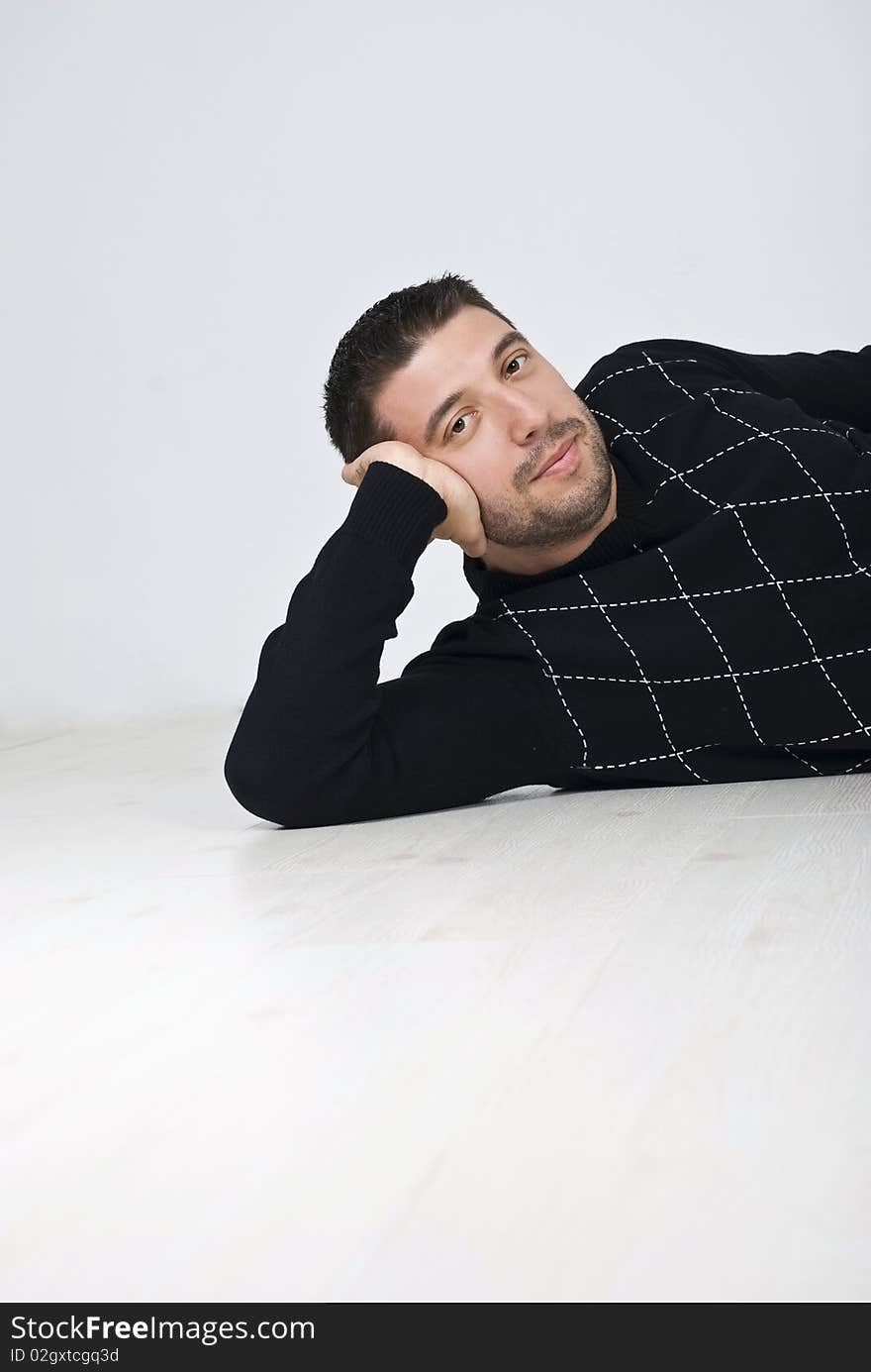 Attractive man sitting on wooden floor