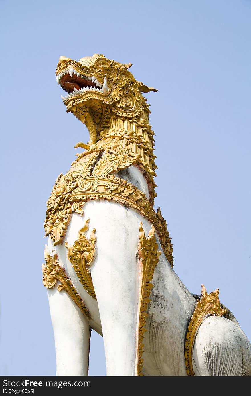 A statue of Singha guarding the door of a temple in Chiang Rai, Thailand. A statue of Singha guarding the door of a temple in Chiang Rai, Thailand