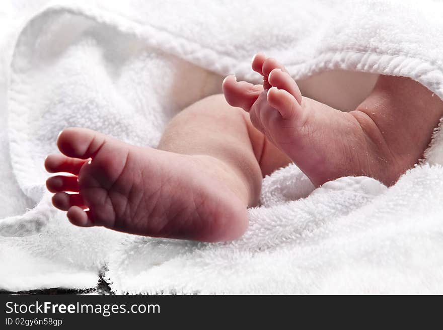 Bare baby feet wrapped in a white towel