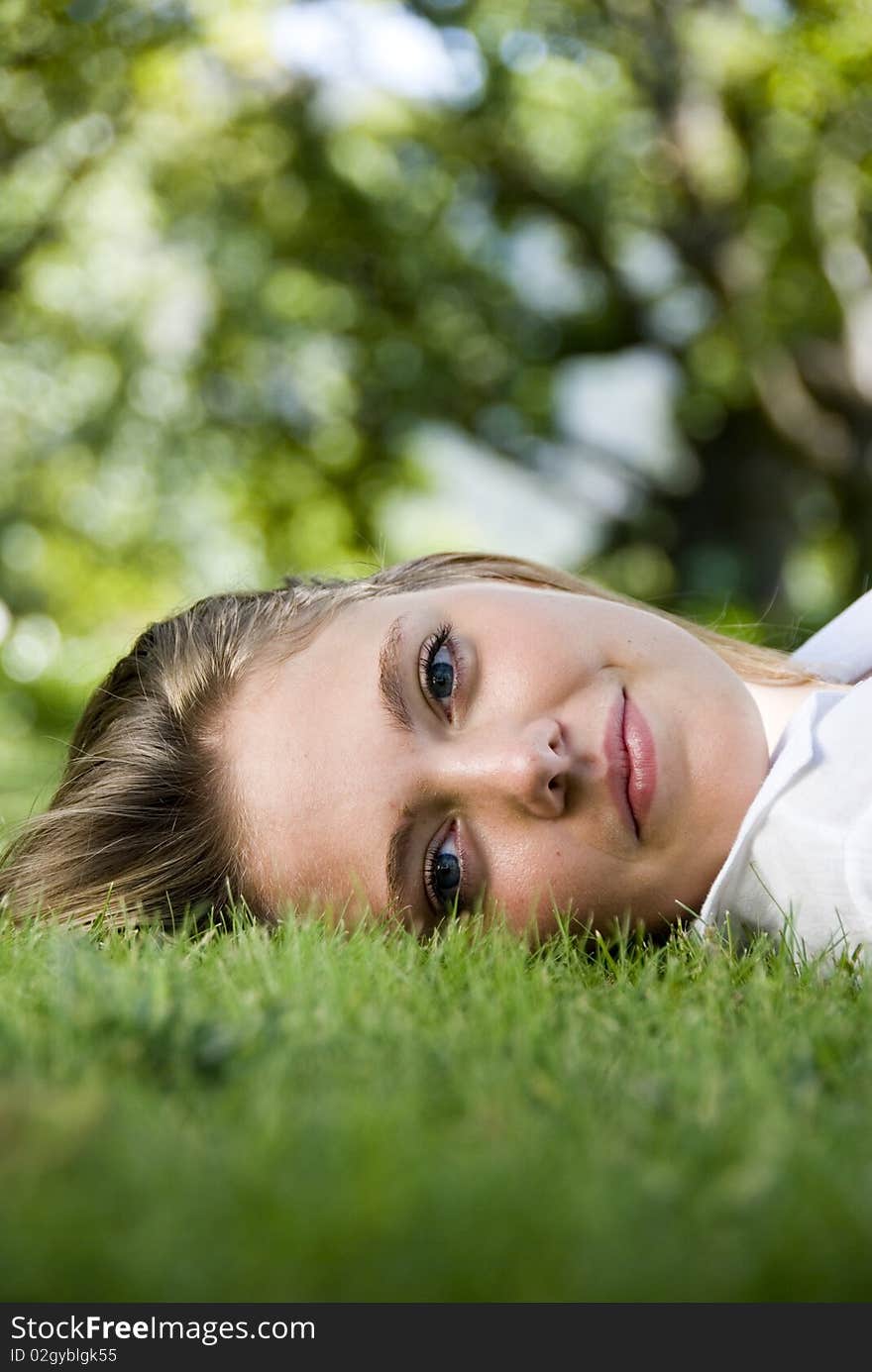 Girl lying on the grass, looking at camera