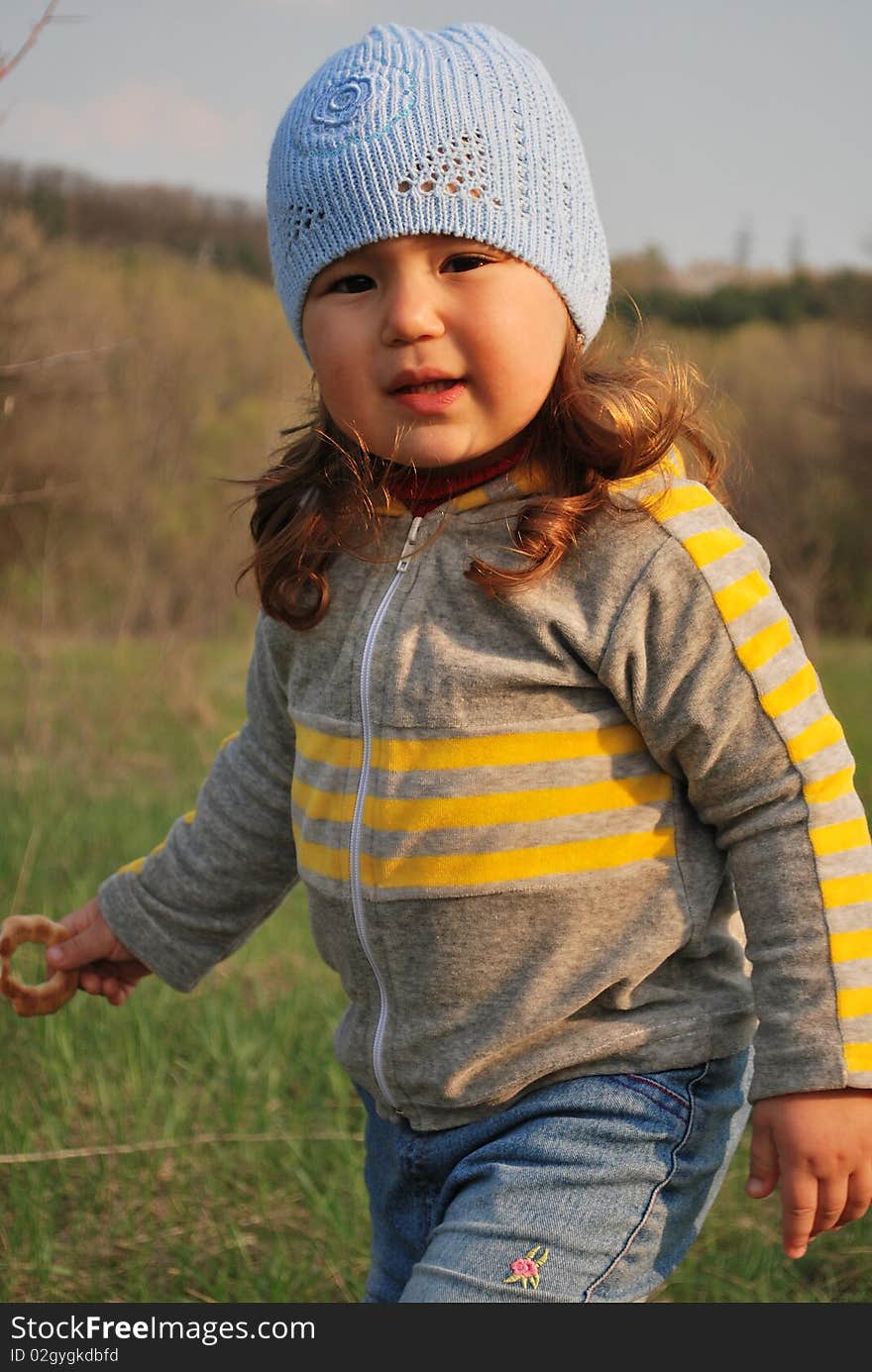 Child with a biscuit outside in early spring