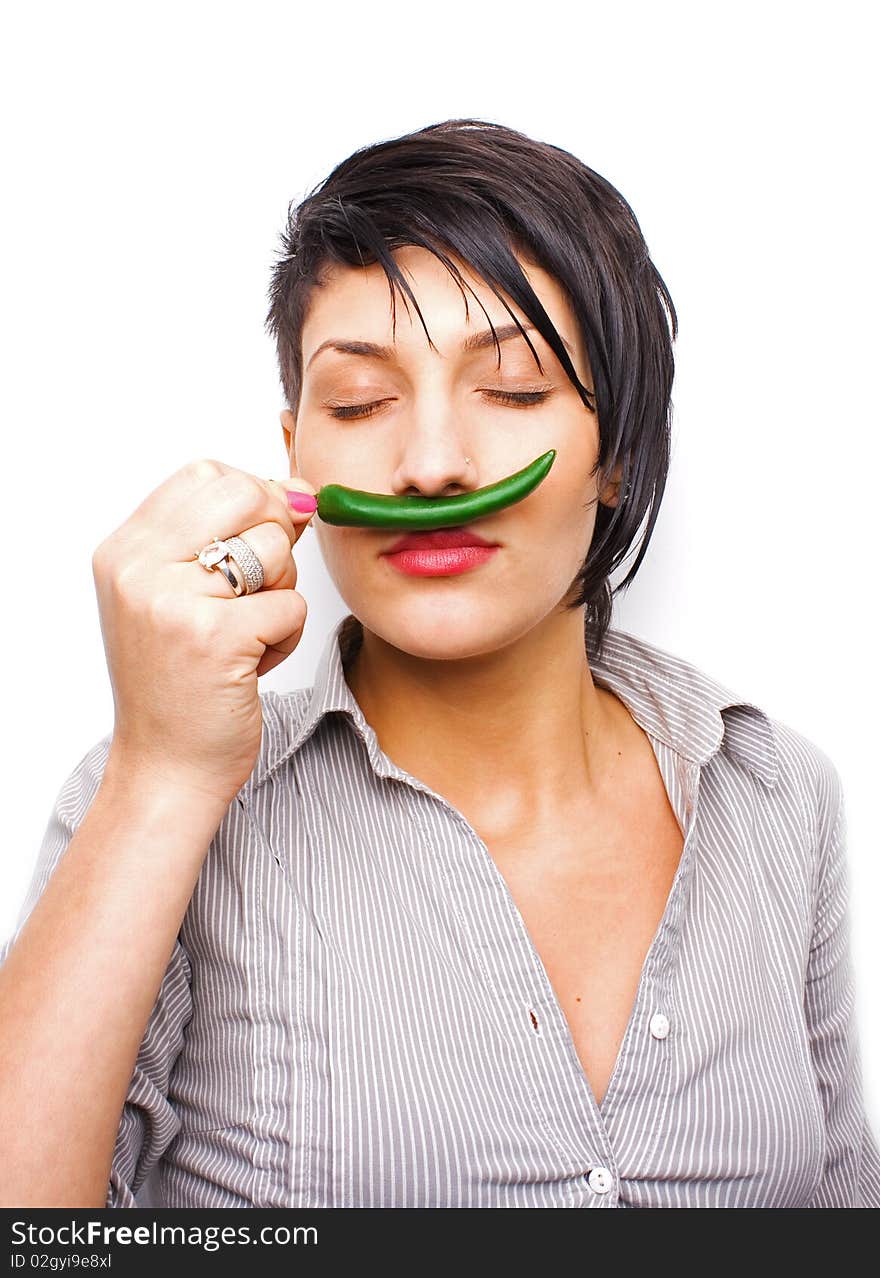 Girl smelling a hot green pepper. Girl smelling a hot green pepper