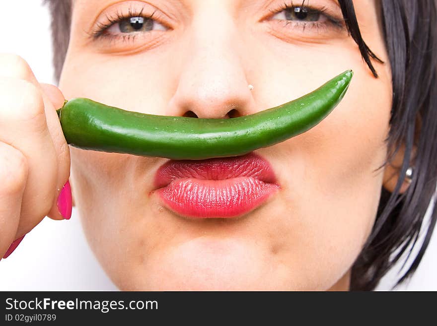 Girl smelling a hot green pepper. Girl smelling a hot green pepper