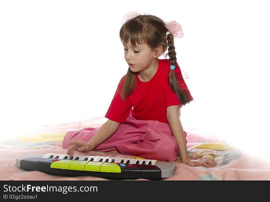 The girl plays a children's musical instrument. The girl plays a children's musical instrument