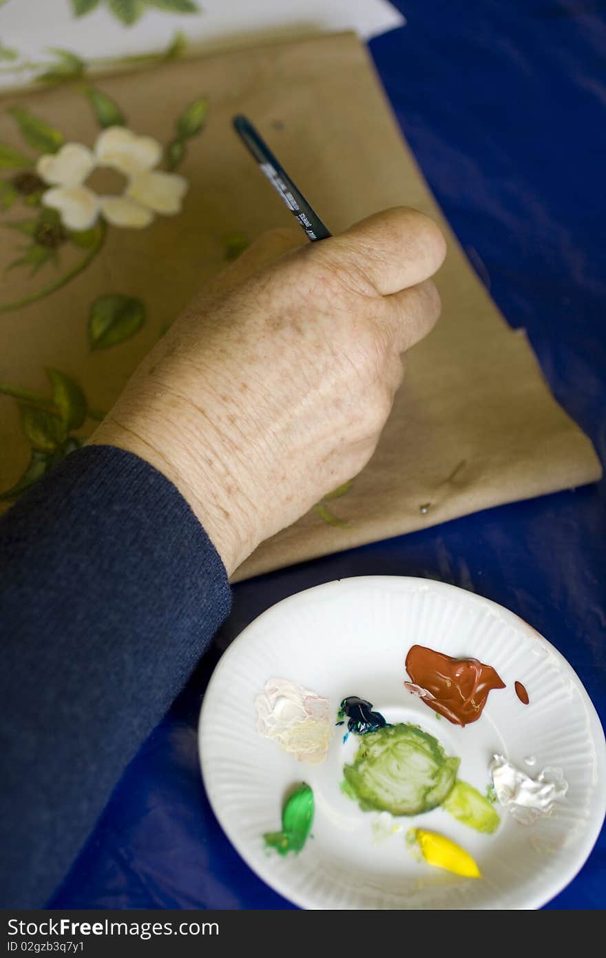 Hand of a Woman in the painting of flowers in a tissue