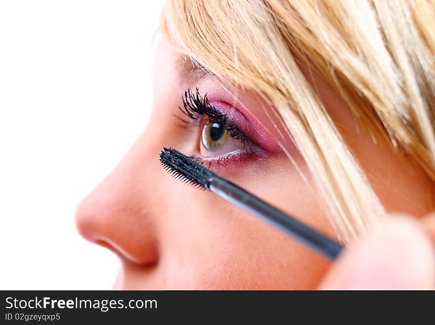 Pretty woman applying make up on a white background. Pretty woman applying make up on a white background