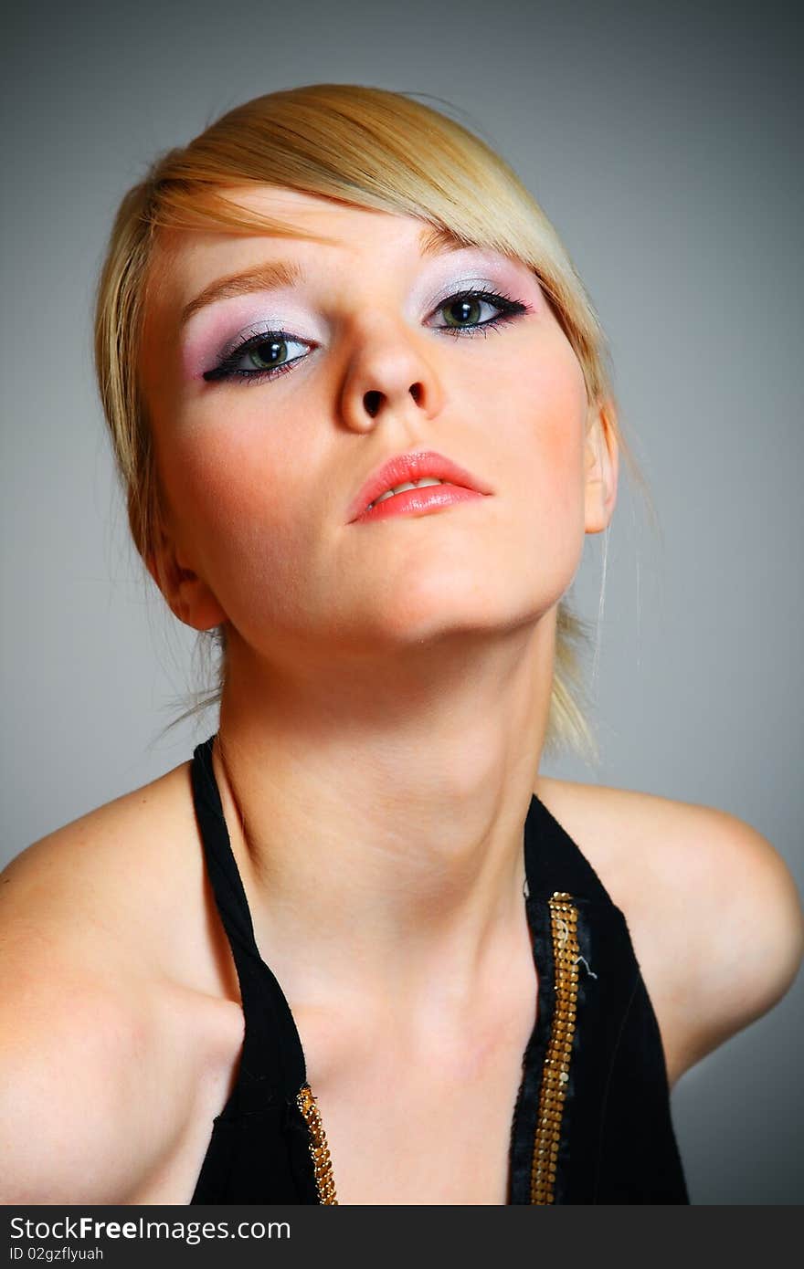 Young woman posing on grey background in black dress. Young woman posing on grey background in black dress