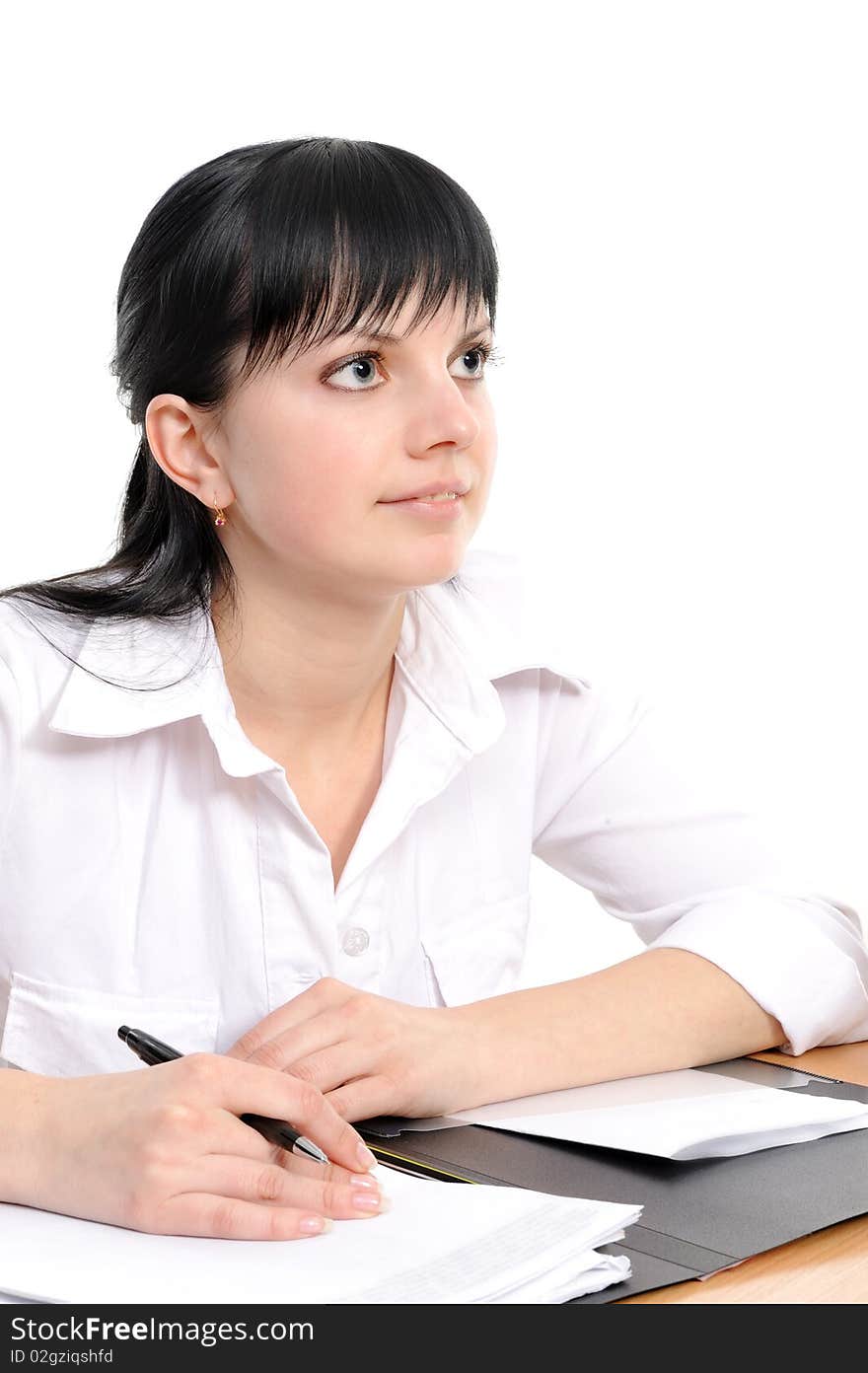 Beautiful young woman in a white shirt sits at a table with the handle in a hand. Beautiful young woman in a white shirt sits at a table with the handle in a hand