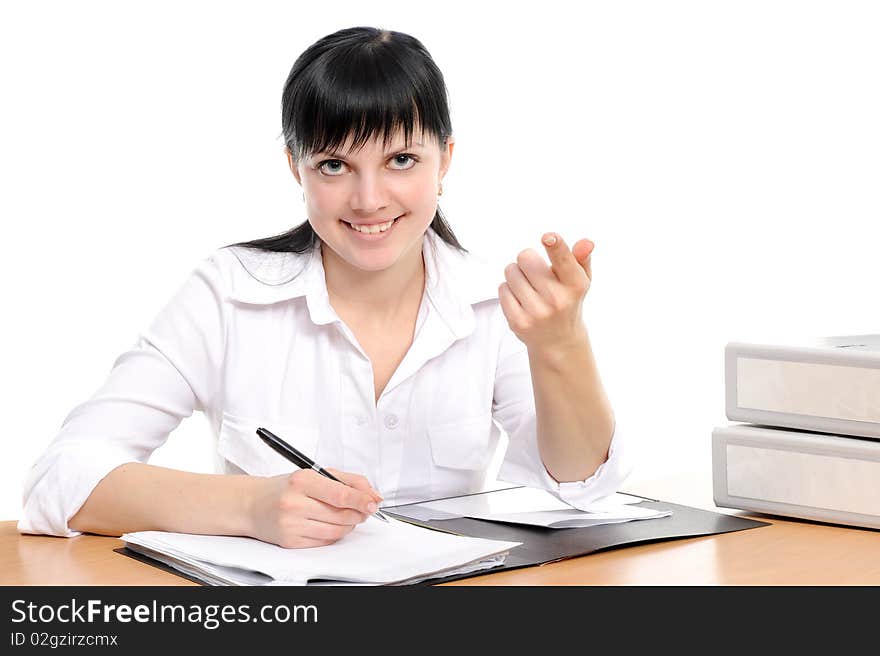 Beautiful young woman in a white shirt sits at a table with the handle in a hand. Beautiful young woman in a white shirt sits at a table with the handle in a hand