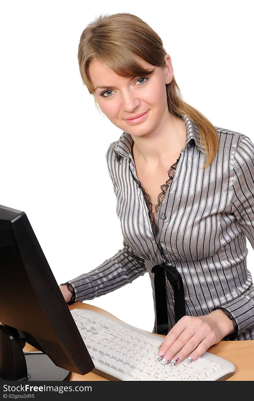 The beautiful smiling  woman  in front of her desktop computer on a white background. The beautiful smiling  woman  in front of her desktop computer on a white background