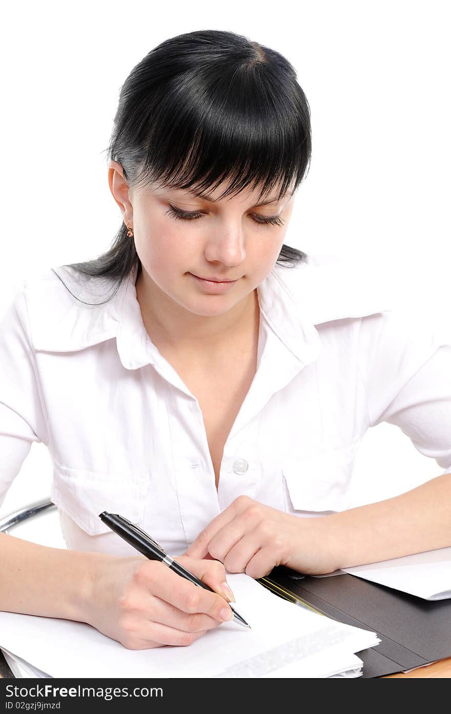 Beautiful young woman in a white shirt sits at a table with the handle in a hand. Beautiful young woman in a white shirt sits at a table with the handle in a hand