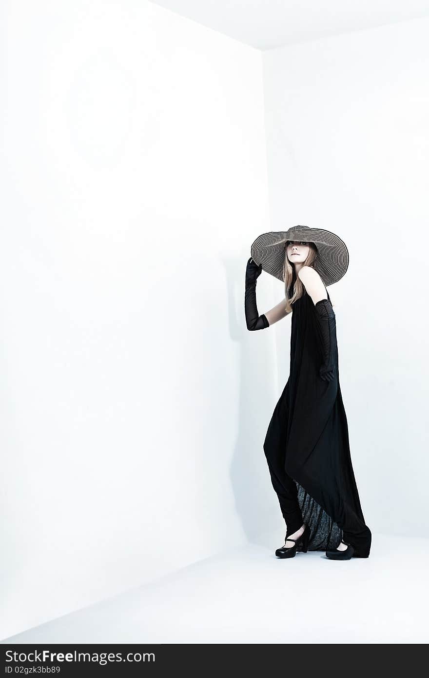 Portrait of a beautiful girl in elegant black dress and a  hat. Portrait of a beautiful girl in elegant black dress and a  hat.