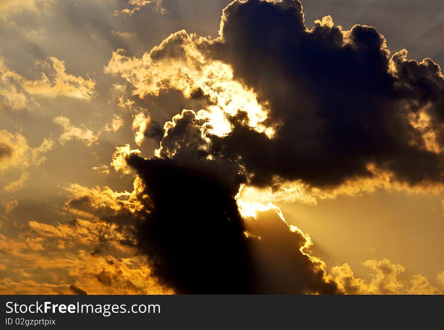 Sun back lit clouds in blue background