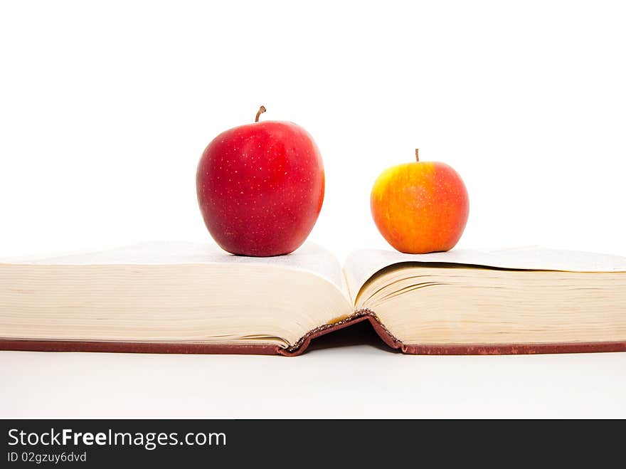 The thick book and apples on a white background