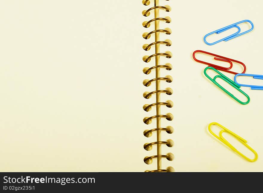 Notebook - empty page and bright paper clips. Notebook - empty page and bright paper clips