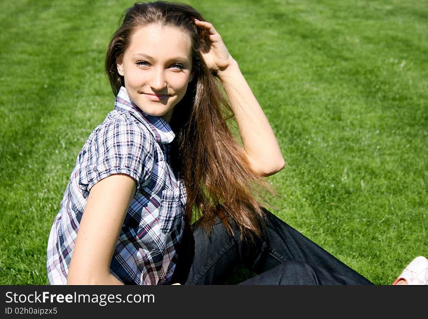 Pretty girl sitting on the green grass