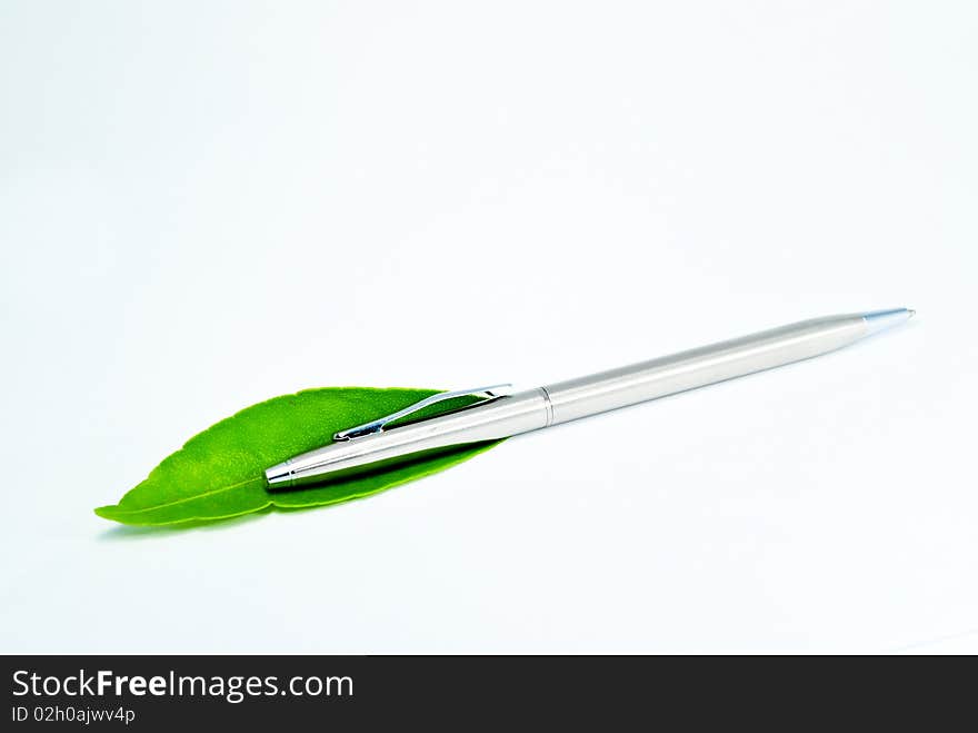 Silver Pen and green leaf in white background. Silver Pen and green leaf in white background.