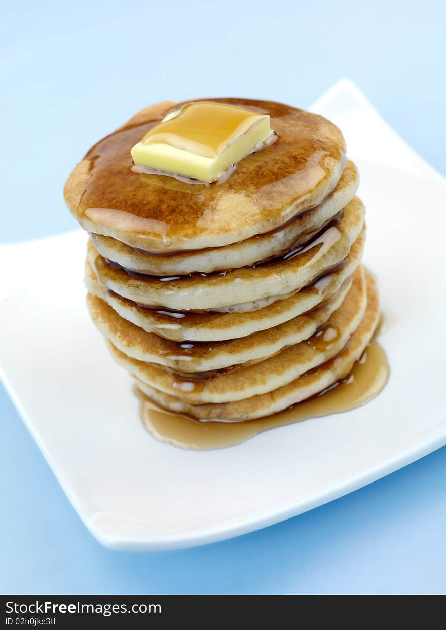 Fresh pancakes isolated against a blue background