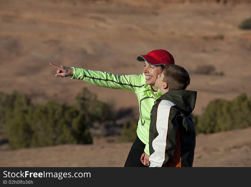 Boy kisses his mother on the cheek while stopping on a hike. Boy kisses his mother on the cheek while stopping on a hike.