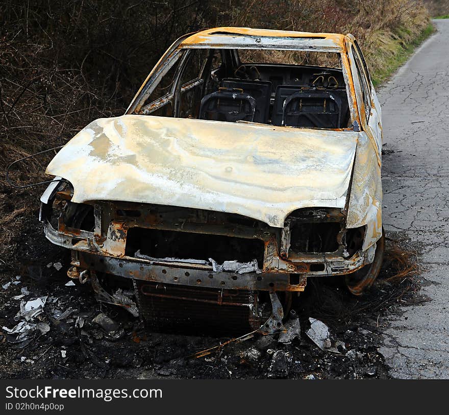 Car burnt out wreckage at side of raod