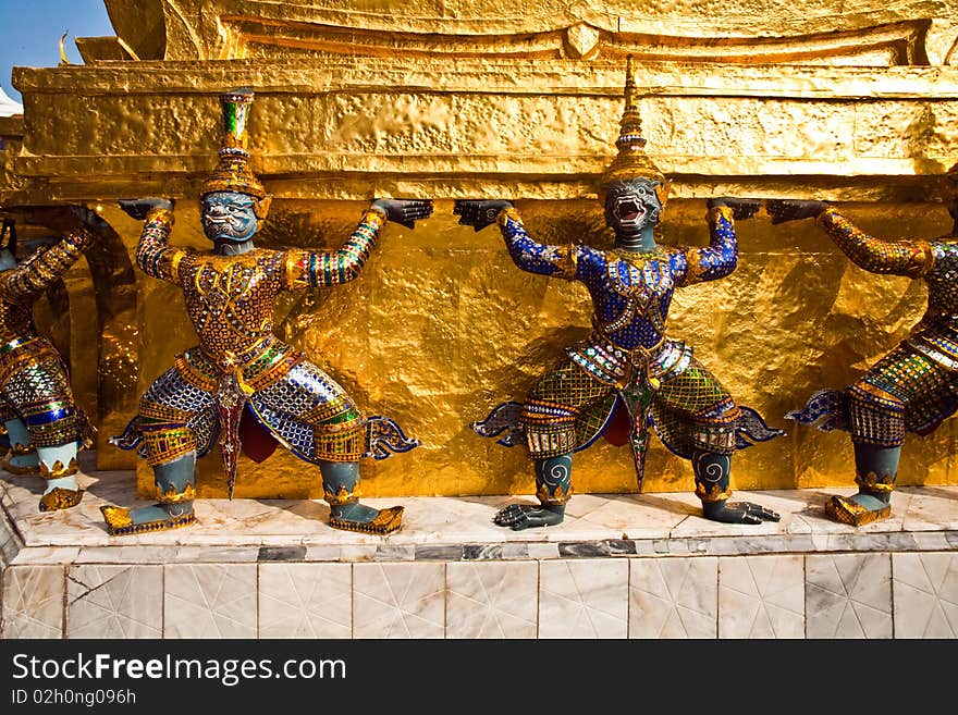 Golden guards are holding the chedi in the inner Grand Palace