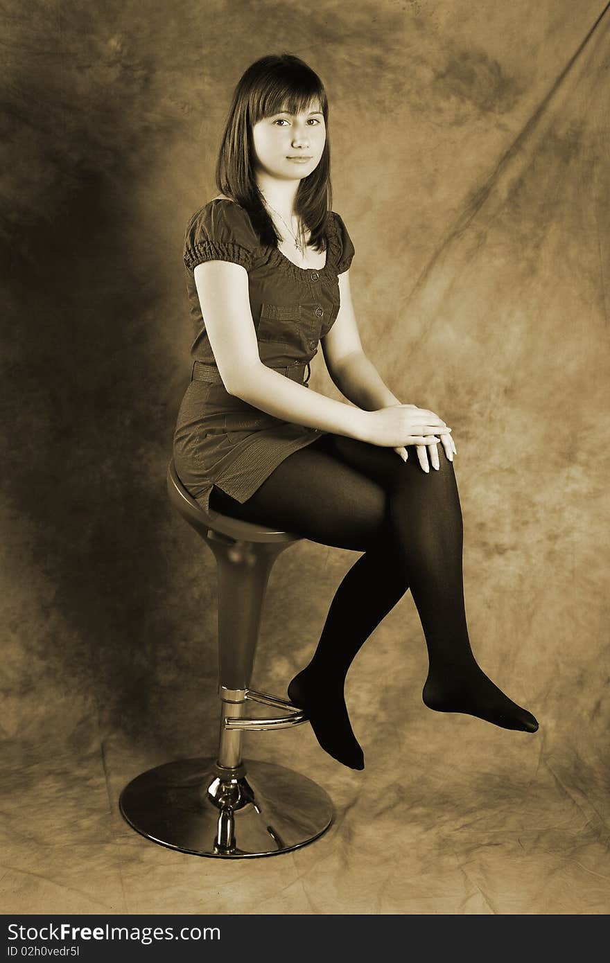 Young woman sitting on a chair and looking at camera. Young woman sitting on a chair and looking at camera