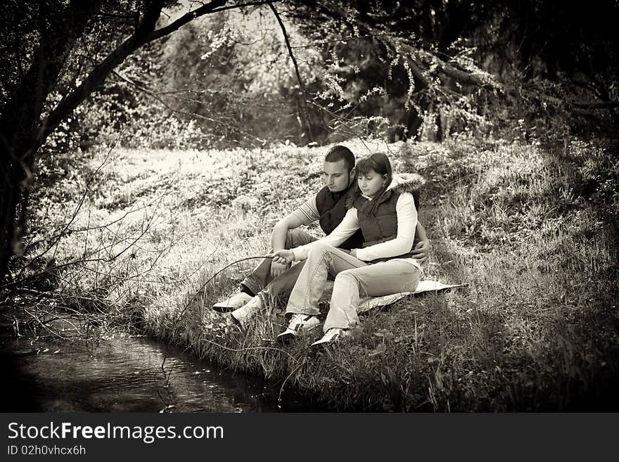 Girl and boy sitting and resting near a river. Girl and boy sitting and resting near a river