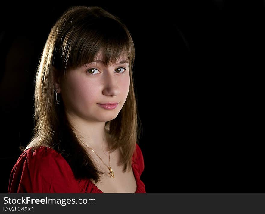 Beautiful girl looking at camera on a black background. Beautiful girl looking at camera on a black background