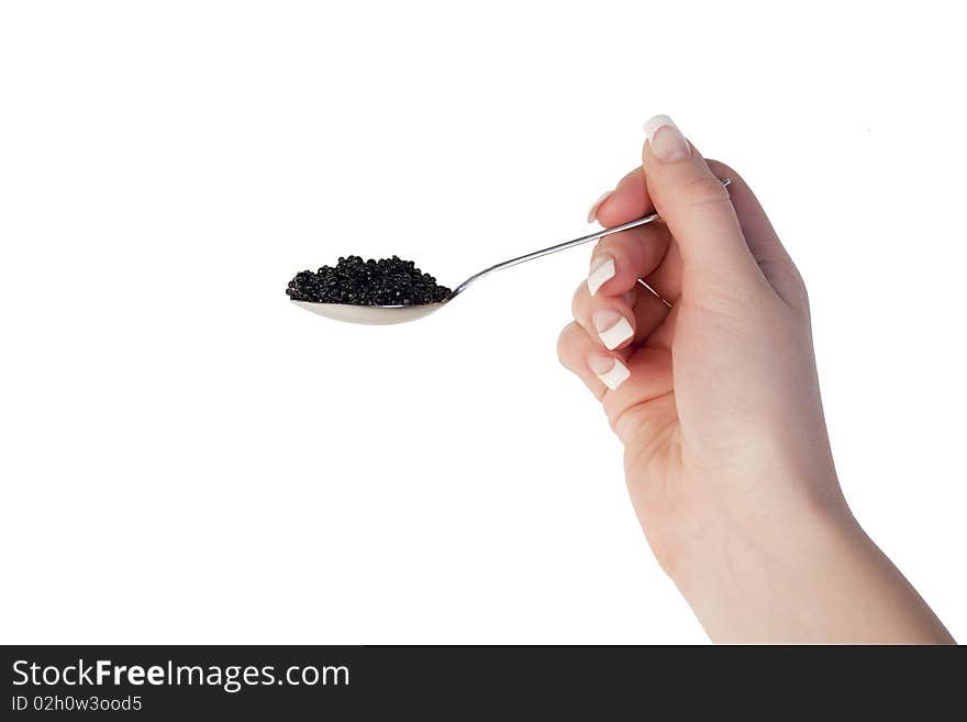 Human hand holding a spoon with black caviar