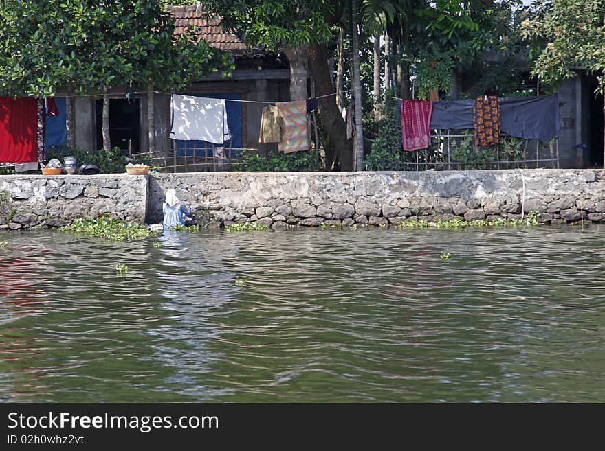 A local woman doing her laundry in the Keralan backwaters, India. A local woman doing her laundry in the Keralan backwaters, India