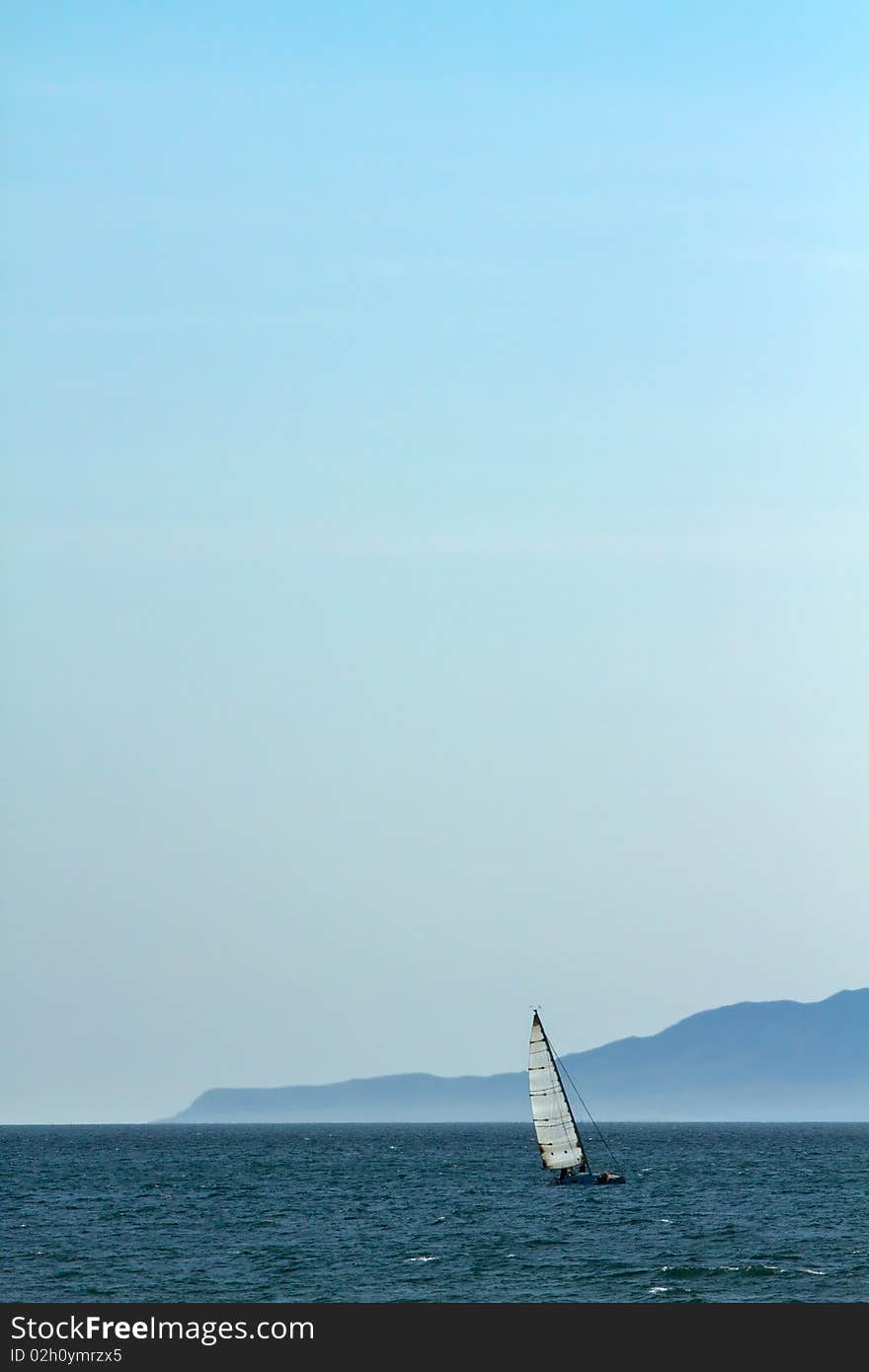 Solitary sailboat at sea on Pacific Ocean. Solitary sailboat at sea on Pacific Ocean.