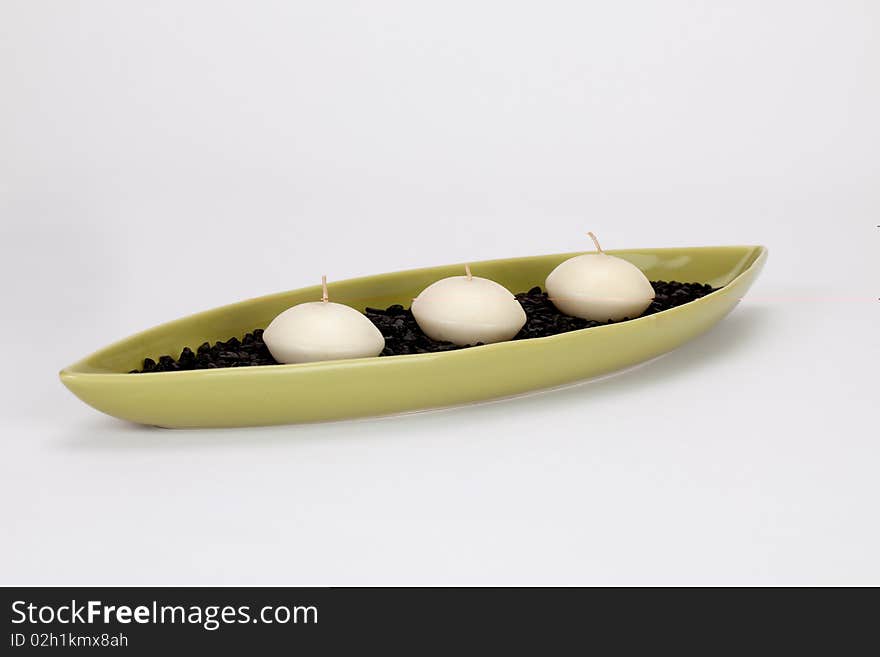 Candle boat with three candles and black pebbles in it. Candle boat with three candles and black pebbles in it.