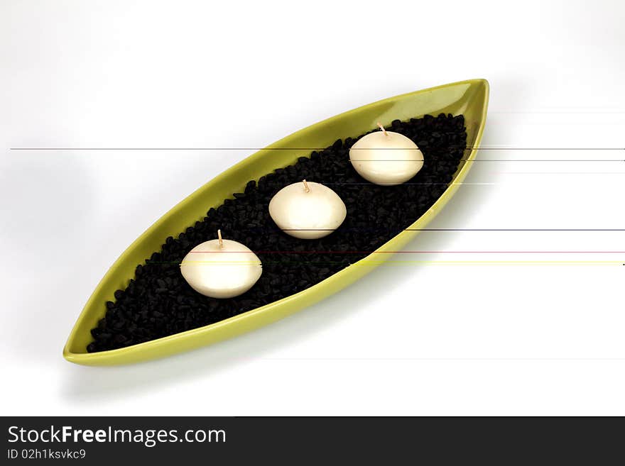 Candle boat with three candles and black pebbles in it. Candle boat with three candles and black pebbles in it.