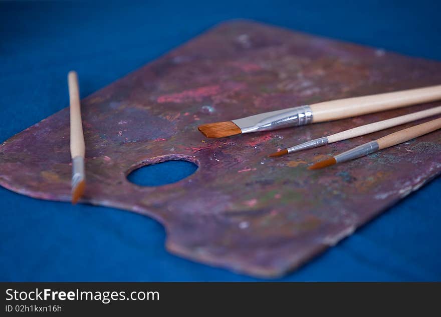 Paint palette and brushes on blue background. Paint palette and brushes on blue background