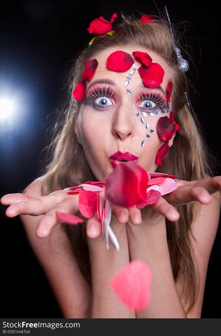 Young stylish fresh young model with an extreme red makeup and roses. Young stylish fresh young model with an extreme red makeup and roses.