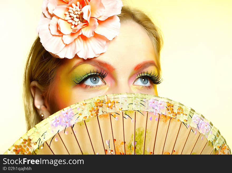 Close-up portrait of summer fashion creative eye make-up in yellow and green tones. Close-up portrait of summer fashion creative eye make-up in yellow and green tones