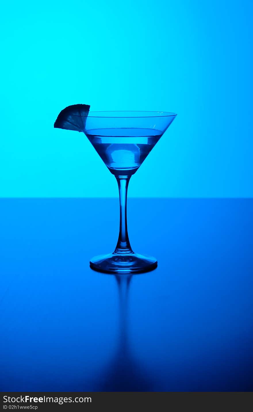 Cocktail glass with blue lit backgrpound. Cocktail glass with blue lit backgrpound